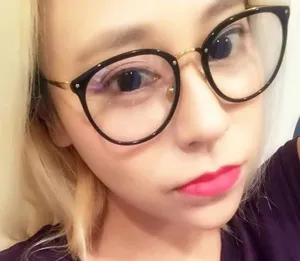 Primer plano de gafas con montura de metal en negro y oro usadas por una modelo