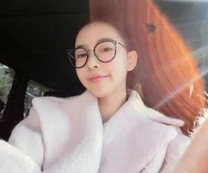 Joven mujer asiática con elegantes gafas redondas negras y doradas en una foto de estilo de vida