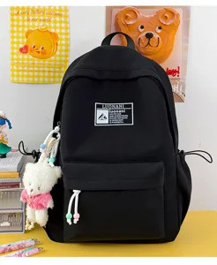 Vista dettagliata dello zaino scolastico nero minimalista con portachiavi a forma di orsetto.