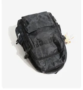 Detailed view of large camouflage backpack with embroidered MGDCH text and plush pendant