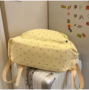 Linda mochila escolar amarilla con patrón de corazones y gran capacidad para niñas en maleta