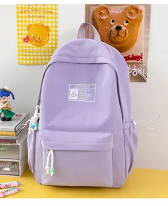 Primo piano di uno zaino scolastico viola con etichetta logo decorativa.
