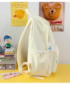 Vista laterale di uno zaino per studenti color crema con simpatici tiri di perline.