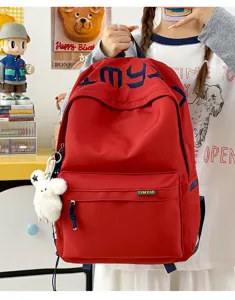 Close-up detail of fashionable red student backpack with navy blue embroidery and brand tag