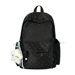 Detalle de mochila negra con lunares y un colgante de peluche de estrella blanca