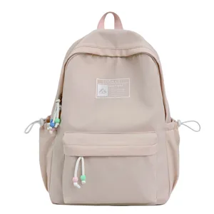 Vista dettagliata dello zaino scolastico beige con toppa LUONANI e ciondoli con perline pastello