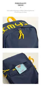 Close-up detail of navy blue student backpack with yellow embroidered letters and zippers.