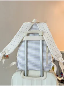 Primer plano de mochila de rayas azules con correas de estrellas en asa de maleta