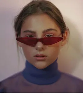 Detailansicht einer trendigen roten Katzenaugen-Sonnenbrille im Retro-Stil an einem Modell.