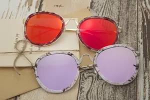 Close-up of stylish round sunglasses with marble-pattern frames and reflective lenses