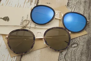 Close-up of oversized round sunglasses with blue mirrored and leopard print frames.