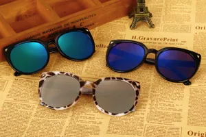 Three pairs of oversized cat-ear sunglasses with blue and silver mirror lenses on vintage paper.
