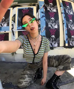 Dettaglio di occhiali da sole cat-eye senza montatura con lenti verdi stile street