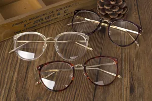 Vista detallada de tres gafas de montura metálica en varios colores sobre madera