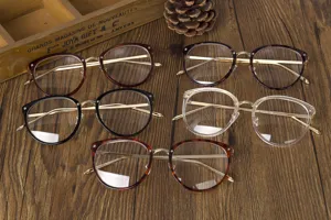 Selección de elegantes gafas con montura de metal en varios colores sobre madera.