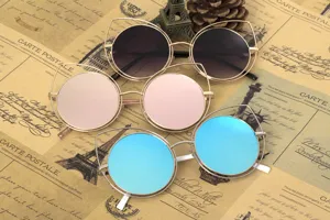 Close-up detail of stylish cat-eye round sunglasses with blue, rose gold and dark lenses