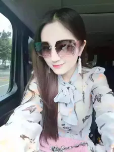 Asian woman wearing oversized gradient sunglasses with crystal decorative frames in a car