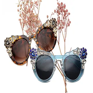 Close-up of floral rhinestone embellished sunglasses in tortoise and blue frames
