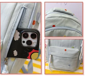 Detailansicht des hellblauen Schülerrucksacks mit seitlicher Reißverschlusstasche und Stickerei.