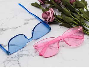 Lunettes de soleil monobloc sans monture avec verres océan bleu et rose sur marbre