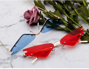 Dettaglio ravvicinato di occhiali da sole cat-eye senza montatura con lenti rosse e blu