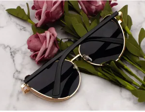 Close-up of trendy women's sunglasses with glitter-decorated gold frames on marble