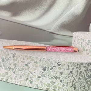 Rose gold ballpoint pen detail showcasing sparkling pink rhinestones and sleek metallic finish.