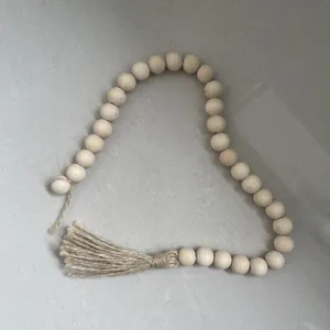 Wooden bead garland with jute tassel detail, natural farmhouse tiered tray decor and accent.