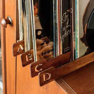 Vista detallada de divisores de discos de madera con letras talladas para orden.