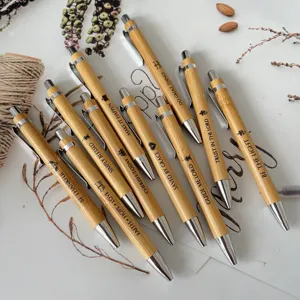 Close-up detail of engraved bamboo ballpoint pens set with inspirational Bible verses.