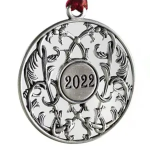 Silver metal Christmas tree ornament with intricate scrollwork and 2022 year stamp.