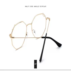 Vue détaillée des lunettes de soleil polygonales surdimensionnées en métal doré avec branches noires