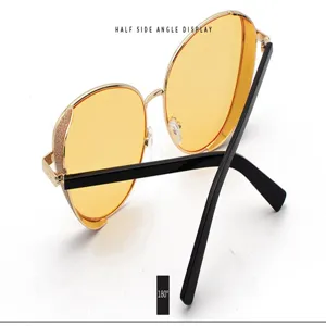 Detail view of women's sunglasses with yellow lenses and glitter metal frame at 180 angle