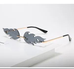 Detalle de gafas de sol de llama sin montura con lentes grises y patillas doradas