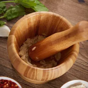 Wooden mortar and pestle detail view, kitchen tool for crushing garlic, herbs and spices.