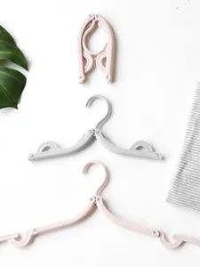 Portable folding clothes hanger detail showing multi-functional plastic design for home use.