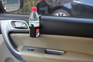 Close-up detail of black car door cup holder showing secure hanging installation and bottle fit.
