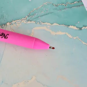 Primo piano penna gel retrattile rosa, scrittura scorrevole per ufficio e scuola quotidiana.