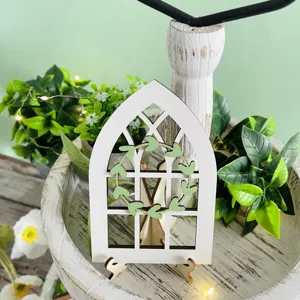 Detailed shot of farmhouse wooden arched window tiered tray decor with green leaf wreath.