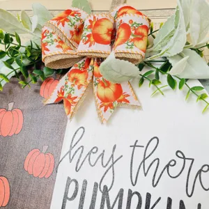 Fall wooden door sign with pumpkin print bow and faux greenery leaves for autumn home decor.