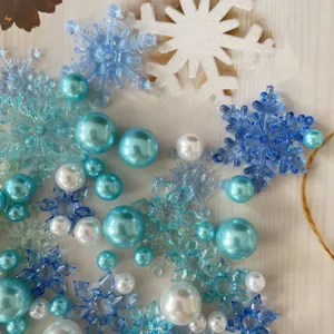Primo piano di fiocchi di neve blu e perle come riempitivo per vasi e decorazioni.