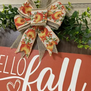 Fall wooden door sign with pumpkin burlap bow and green leaves autumn home decor detail