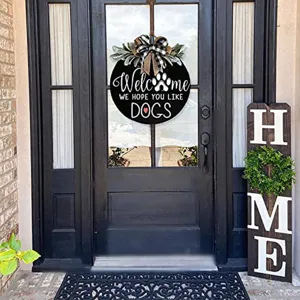 Wooden dog welcome door sign with bow detail hanging on front porch for pet lovers decor.