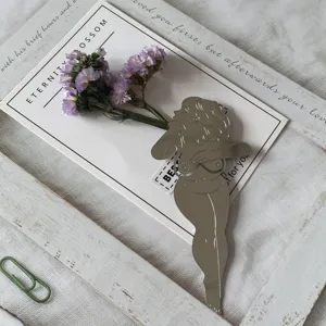Gros plan détaillé du marque-page élégant en silhouette féminine dorée avec des fleurs.