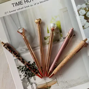 Close-up detail of decorative ballpoint pens set with diamond heart pearl and glitter designs.