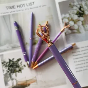 Detail shot of purple crown ballpoint pen set, rose gold top, elegant stationery item.