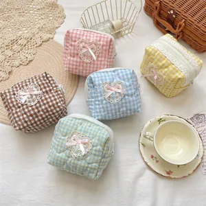 Cute quilted makeup bag with plaid pattern, lace heart and 3D bow for portable cosmetic storage.