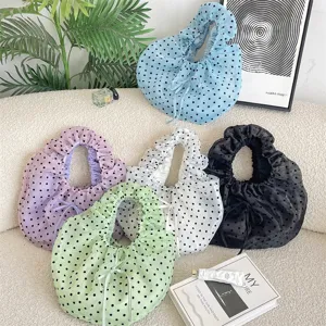 Vista detallada de bolsos de organza con lunares en varios colores y diseño plisado
