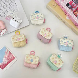 Vista detallada de fundas acolchadas para auriculares con flores en tonos pastel.