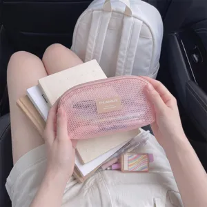 Detailed close-up showing the pink mesh texture of a shell-shaped makeup pouch being held